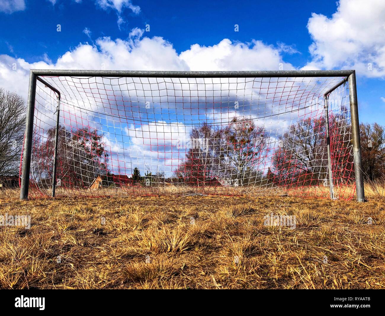 soccer goal on countryside, low angle view of rural soccer field - Stock Photo