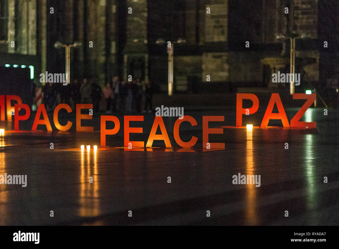 Auf dem Roncalliplatz sind Schriftzuege mit dem Wort 'Frieden' in verschiedenen Sprachen angeleuchtet von Kerzen aufgestellt bei DONA NOBIS PACEM, Gen Stock Photo
