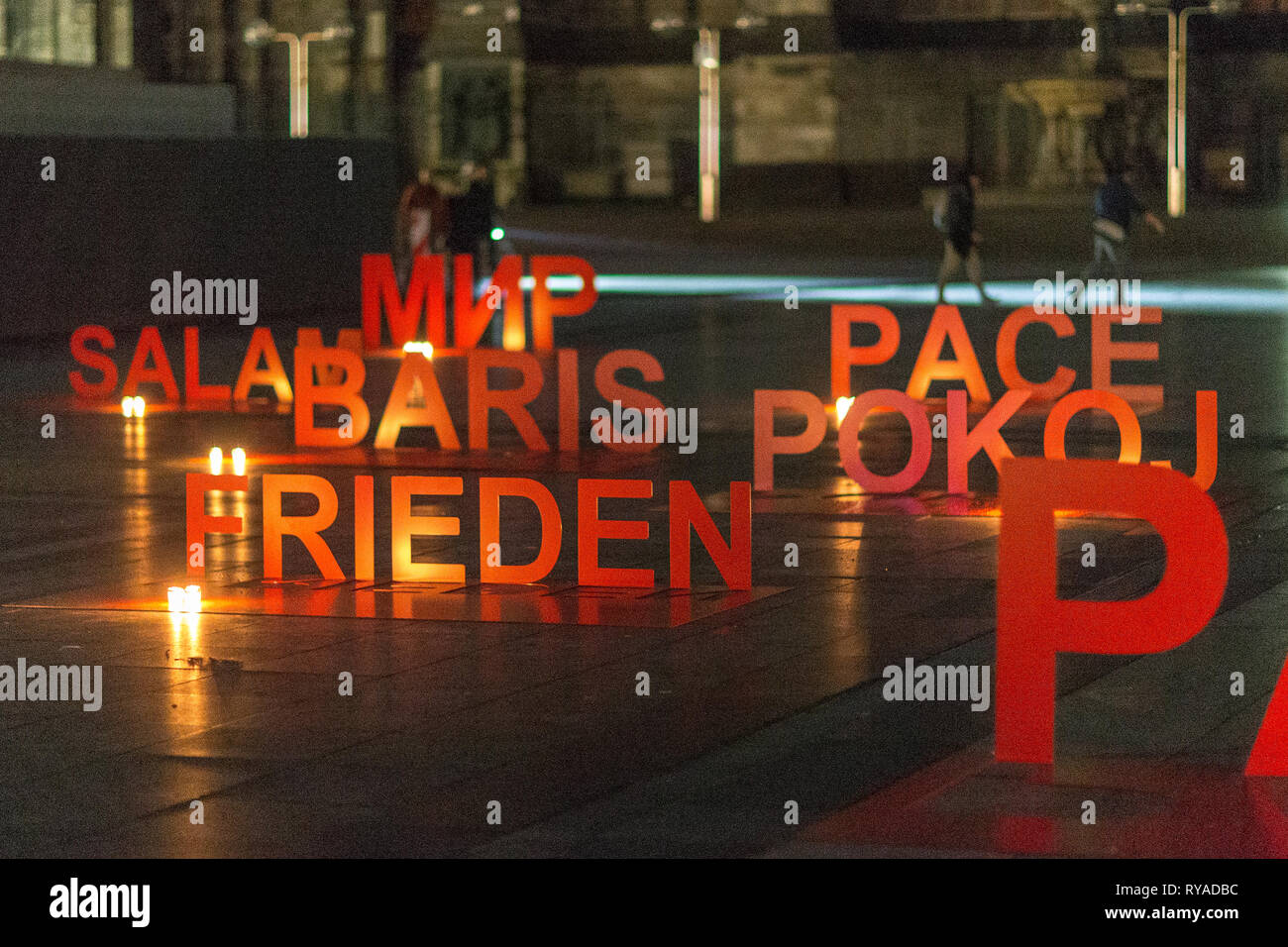 Auf dem Roncalliplatz sind Schriftzuege mit dem Wort 'Frieden' in verschiedenen Sprachen angeleuchtet von Kerzen aufgestellt bei DONA NOBIS PACEM, Gen Stock Photo