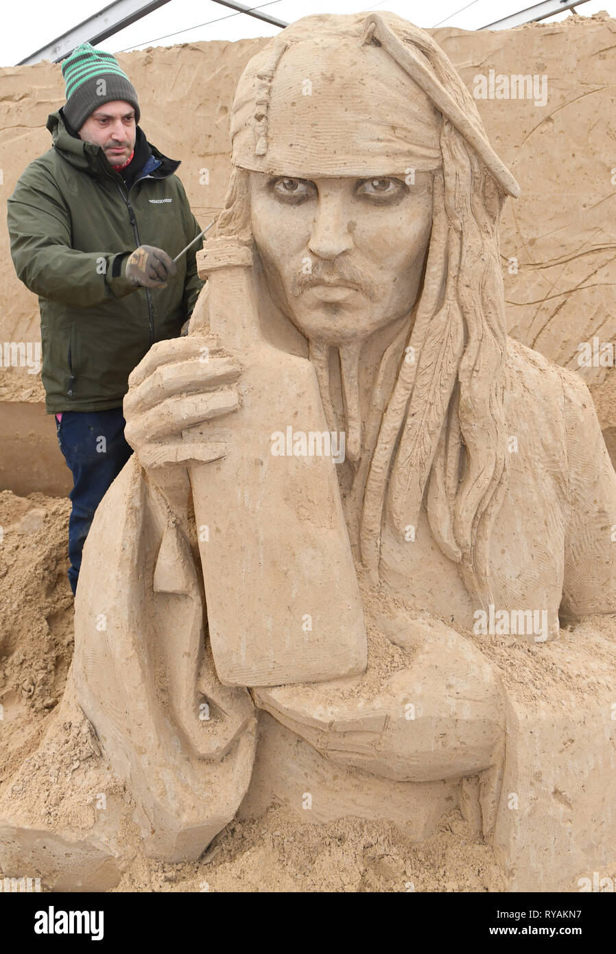 Binz, Germany. 12th Mar, 2019. The sculptor Bagrat Stepanayan from Russia is working on the sand sculpture Johnny Depp as Captain Jack Sparrow in a scene of the film 'Pirates of the Caribbean' on the grounds of the Sand Sculpture Festival. Artists from various European countries are currently creating 45 huge figures for the 10th Sand Sculpture Show in the Baltic seaside resort of Binz. The sand sculpture show opens on 16.03.2018. Credit: Stefan Sauer/dpa-Zentralbild/dpa/Alamy Live News Stock Photo