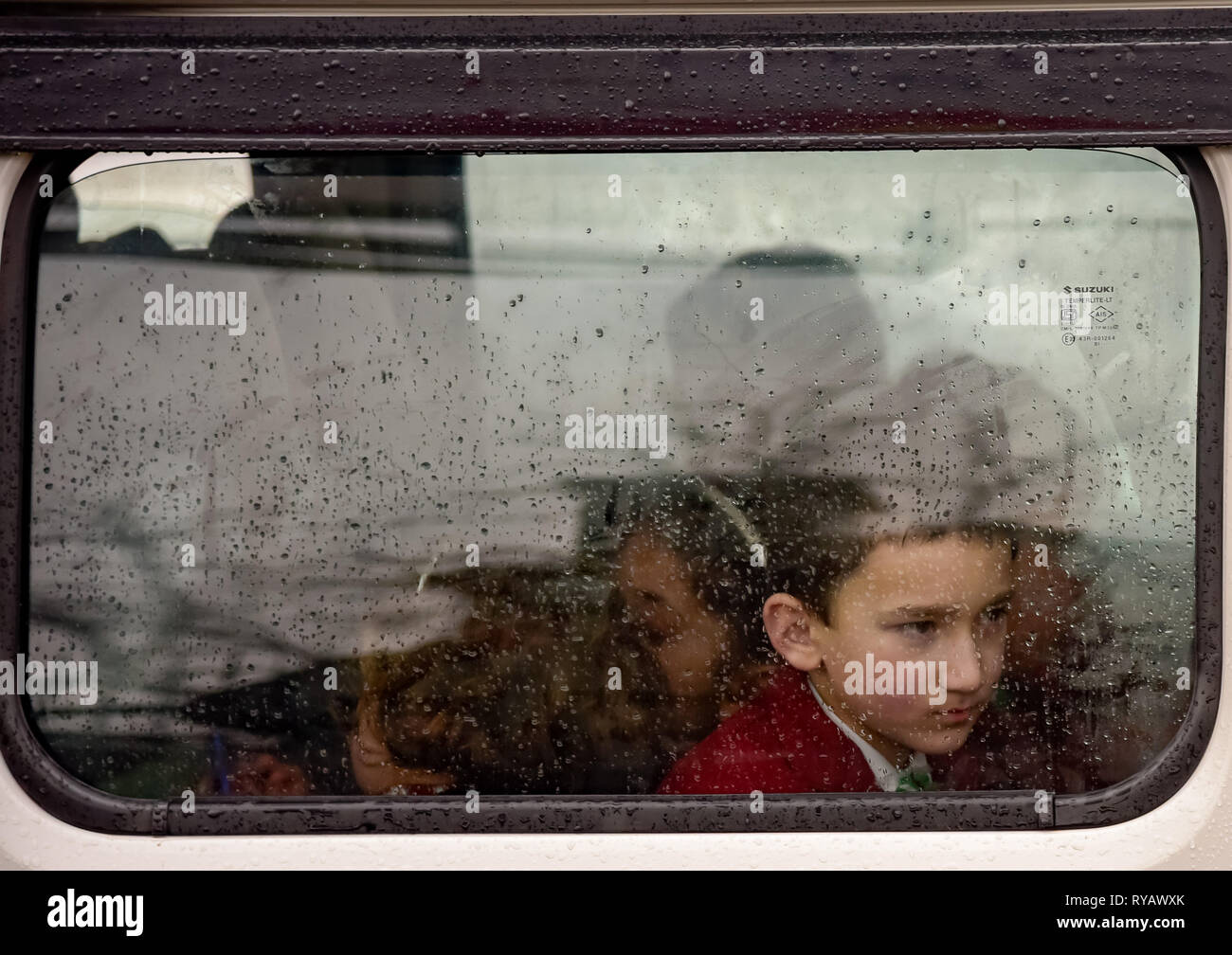Srinagar, Jammu and Kashmir, India. 13th Mar, 2019. A Kashmiri school boy seen gesturing out of rain soaked window of vehicle on a rainy day in Srinagar. Credit: Idrees Abbas/SOPA Images/ZUMA Wire/Alamy Live News Stock Photo