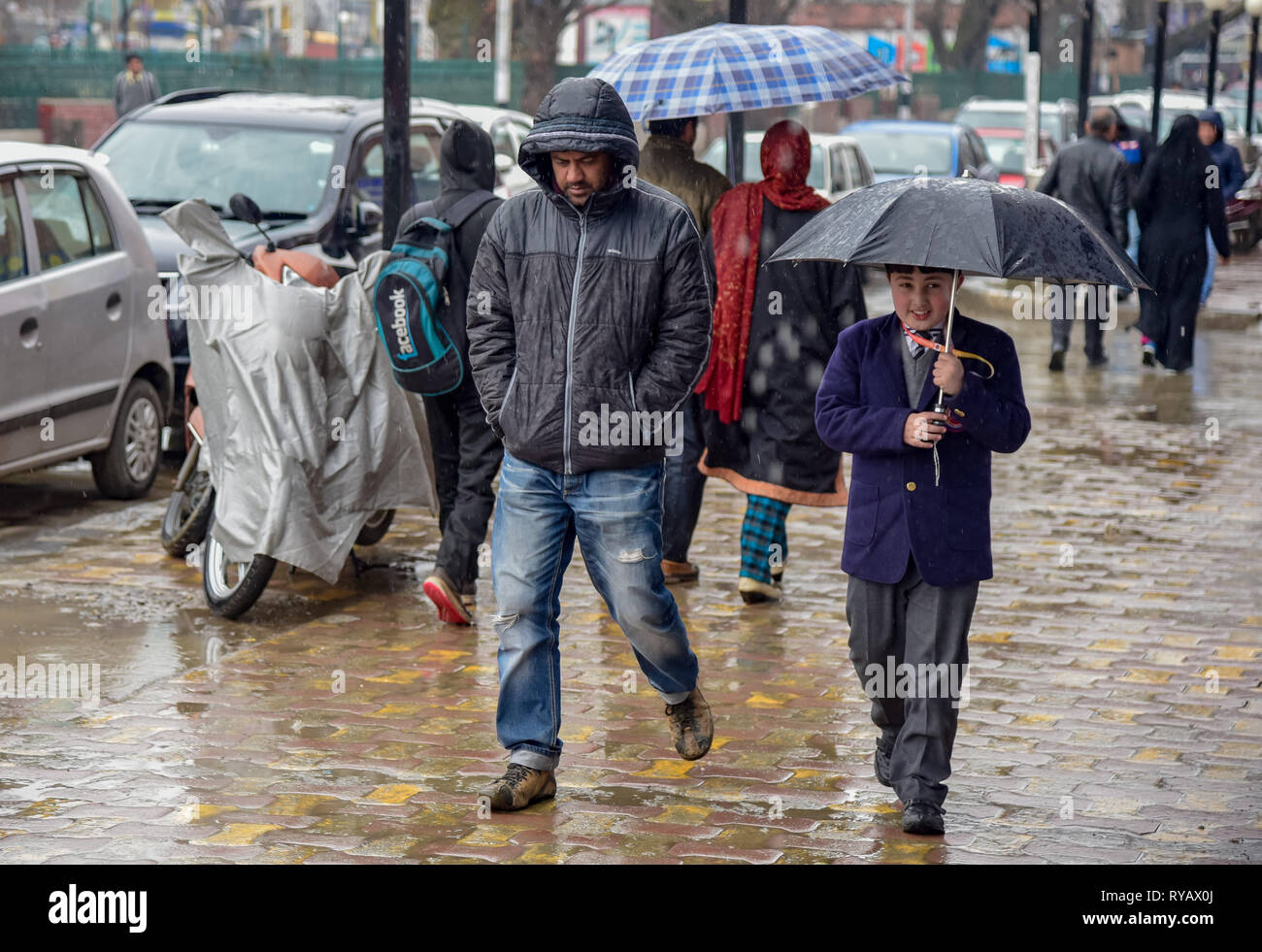 March 13, 2019 - Srinagar, Jammu and Kashmir, India - Kashmiri residents are seen walking on the street during rainy day in Srinagar. (Credit Image: © Idrees Abbas/SOPA Images via ZUMA Wire) Stock Photo