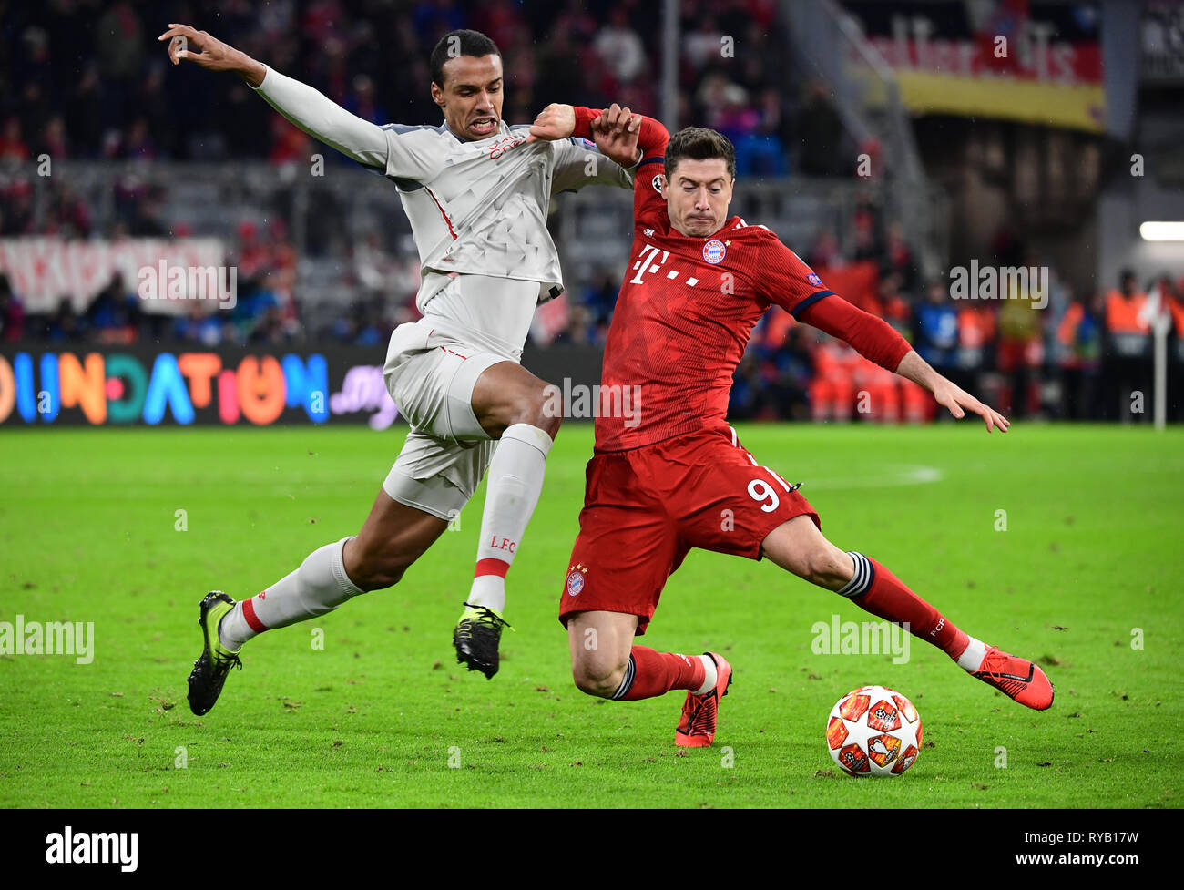 Munich, Germany. 13th Mar, 2019. Soccer: Champions League, knockout round, round of sixteen, second leg: FC Bayern Munich - FC Liverpool in the Allianz Arena. Munich's Robert Lewandowski (r) and Liverpool's Joel Matip fight for the ball. Credit: Peter Kneffel/dpa/Alamy Live News Stock Photo