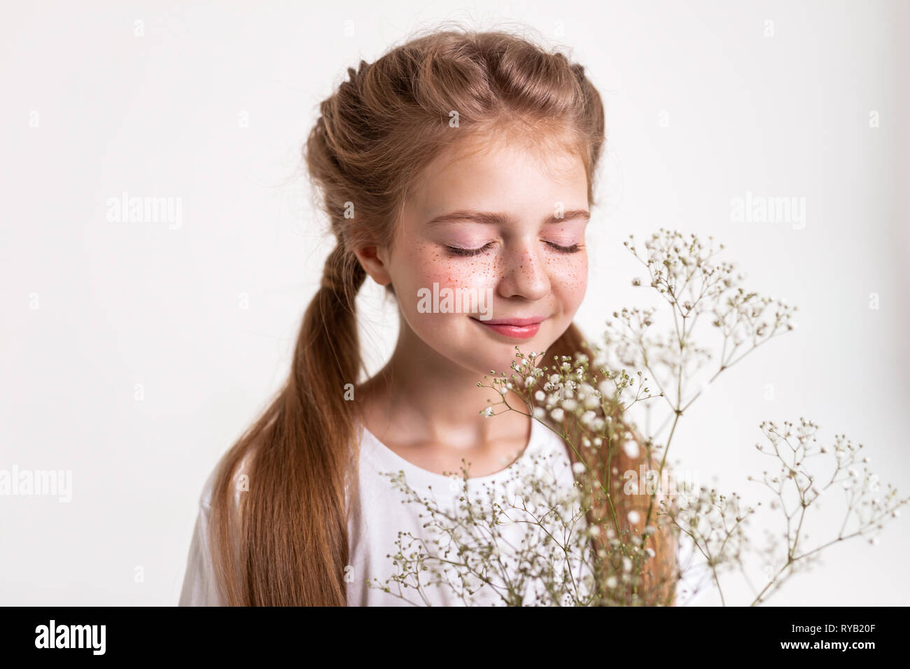 Inspired tranquil little girl smelling scent of flowers Stock Photo Alamy