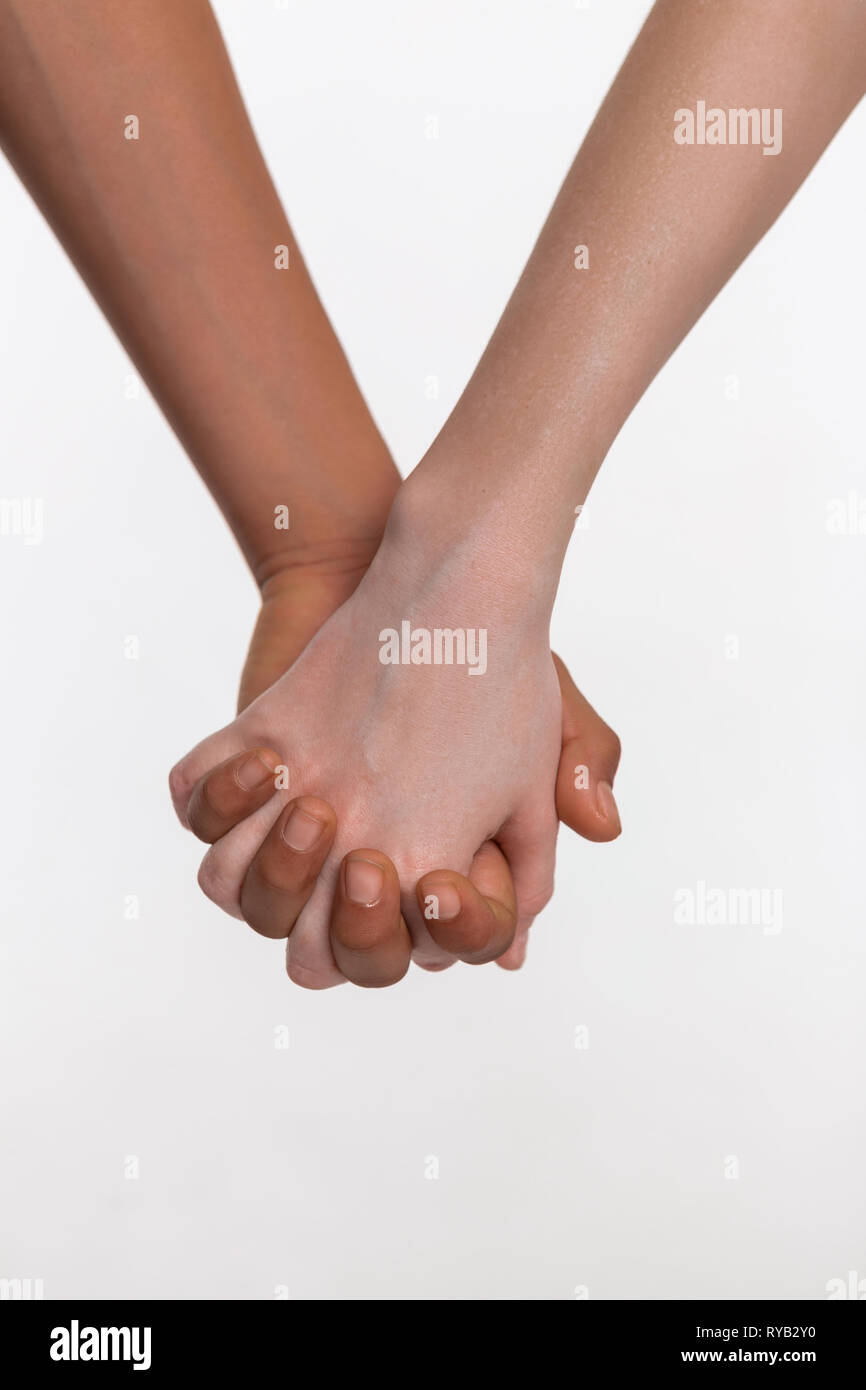 Pale little hands binding fingers with accurate bronzed hand Stock Photo