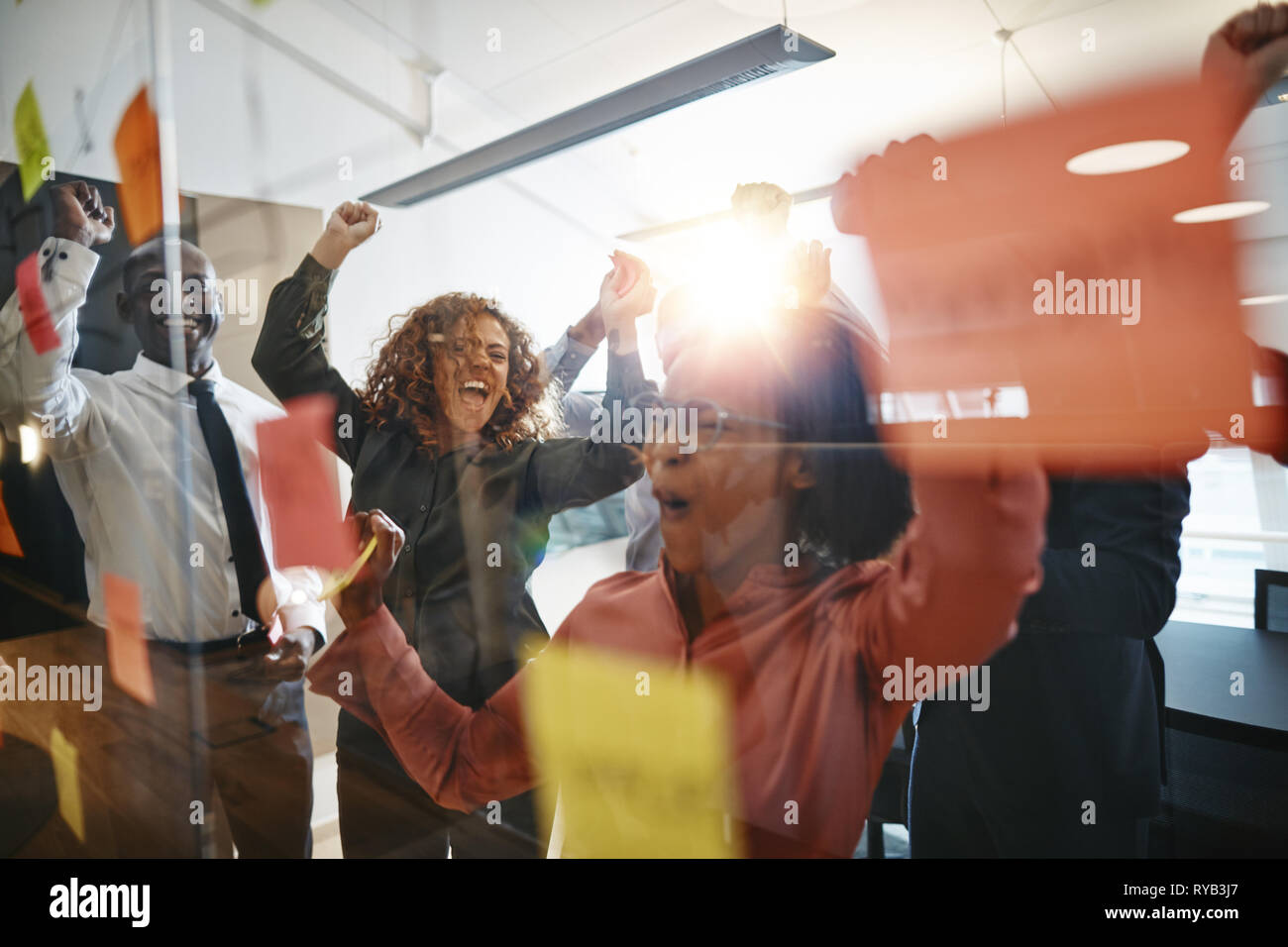 Diverse group of ecstatic businesspeople cheering and jumping up and ...