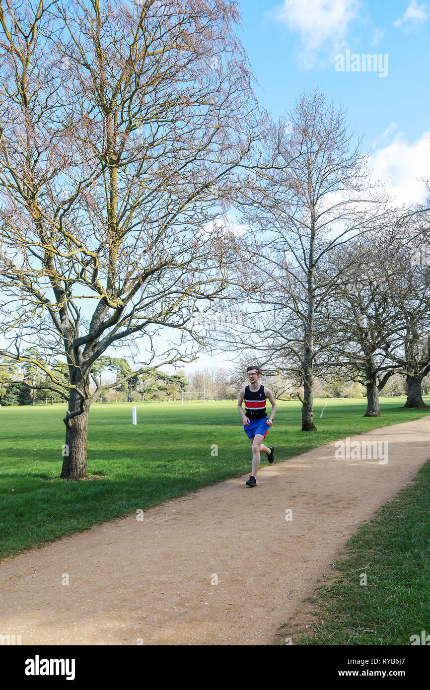Male runner running jogging on a gravel path track in Oxford University