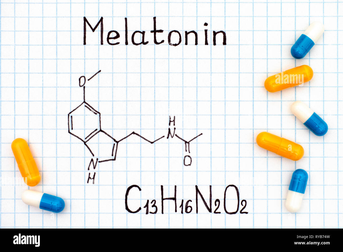 Chemical formula of Melatonin with some pills. Close-up. Stock Photo