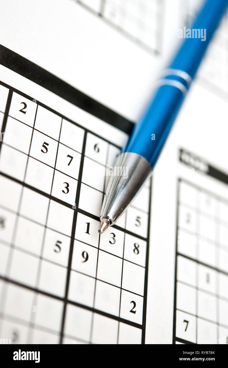 blue pen and a book with Sudoku puzzles to solve Stock Photo