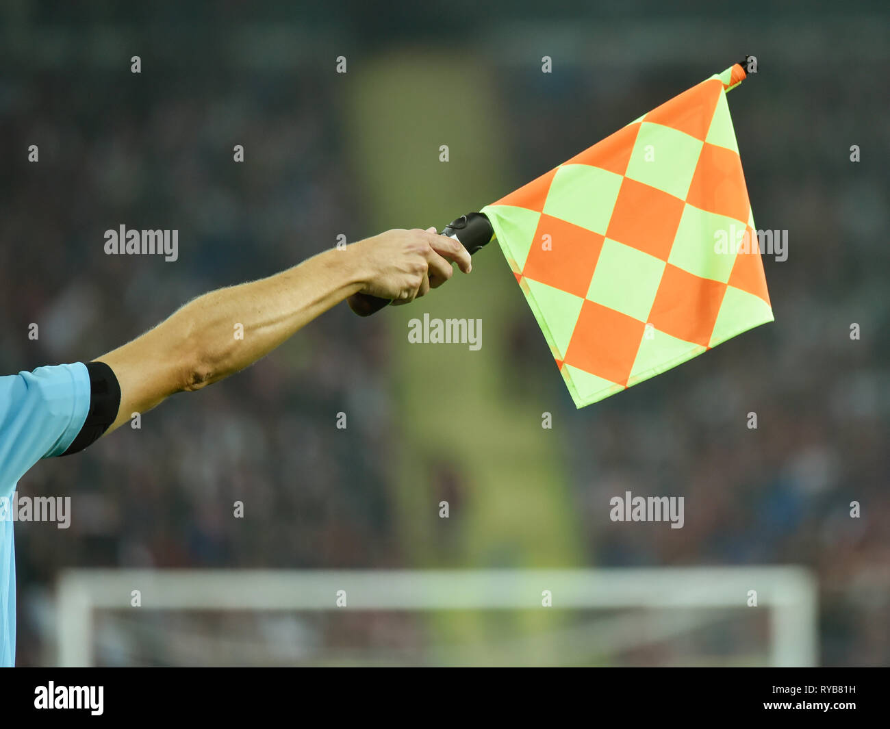 Raised hand with flag of assistant soccer referee Stock Photo