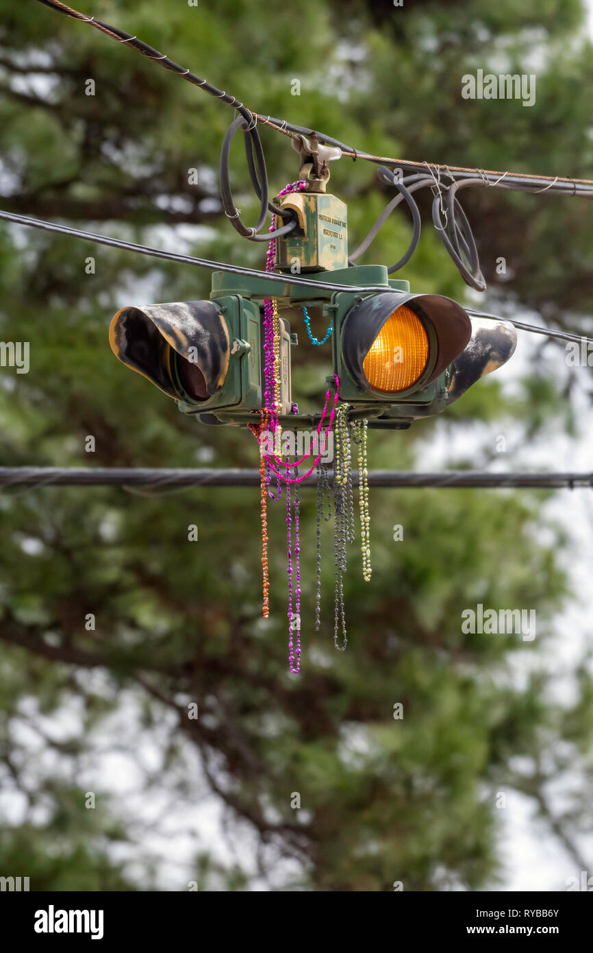 SHREVEPORT, LA., U.S.A. - March 8, 2019: Mardi Gras beads thrown from floats during a parade decorate a traffic signal. Stock Photo