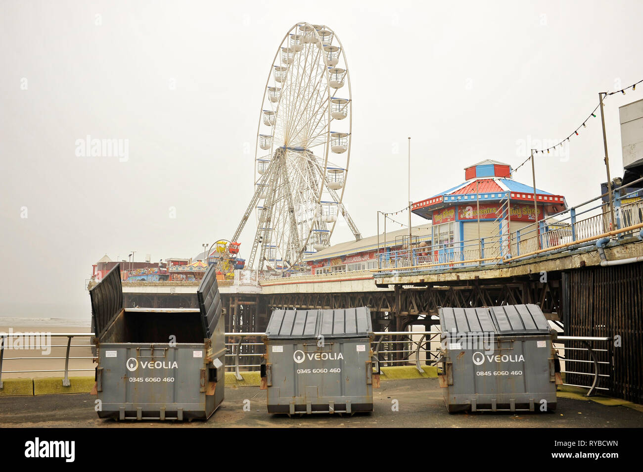 Three rubbish skips in front of Central Pier and Ferris wheel,Blackpool,UK Stock Photo