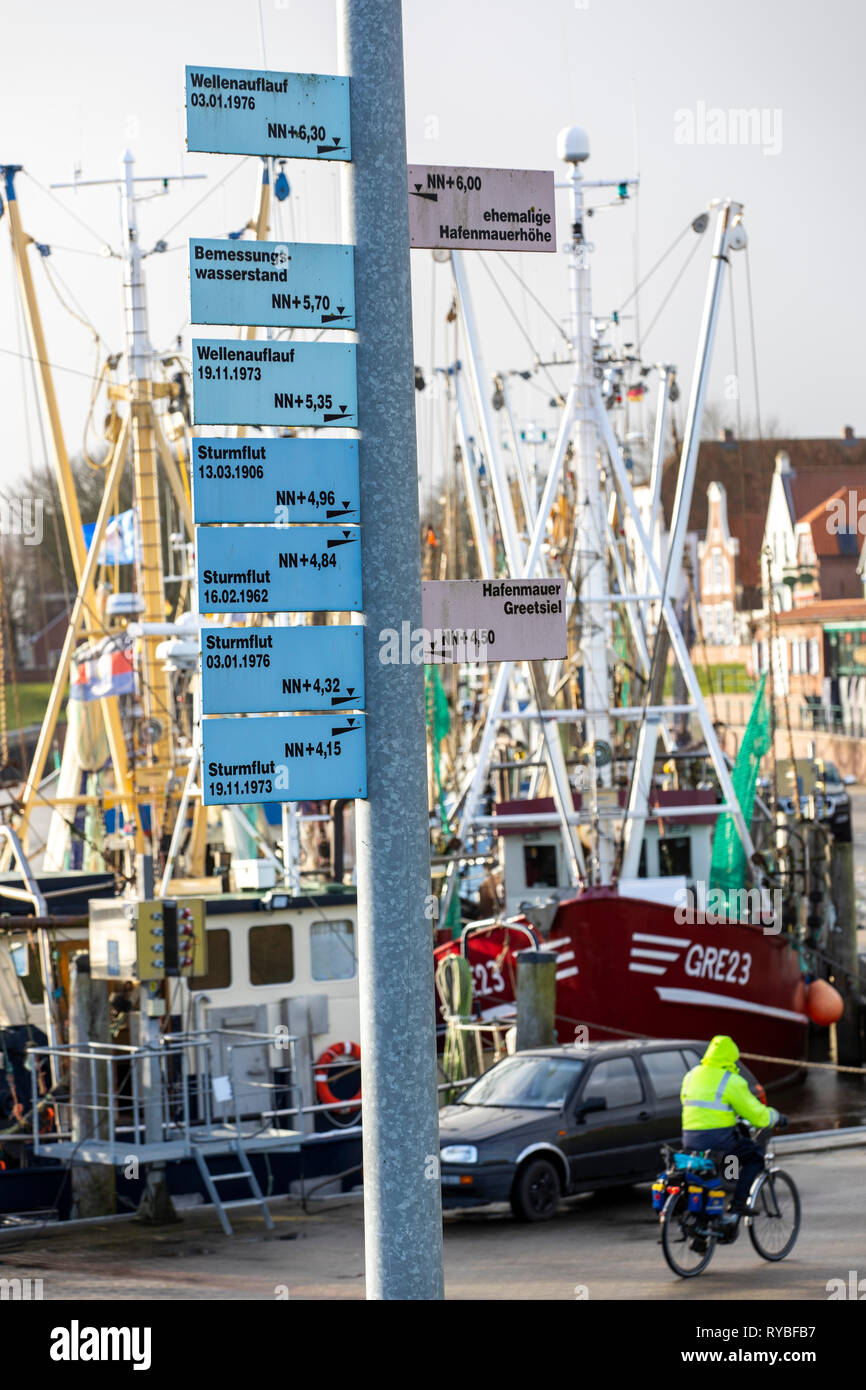 Sign shows the hight of extrem floods during storms,  in the fishing port of Greetsiel, Ostfriesland, Lower Saxony, Stock Photo