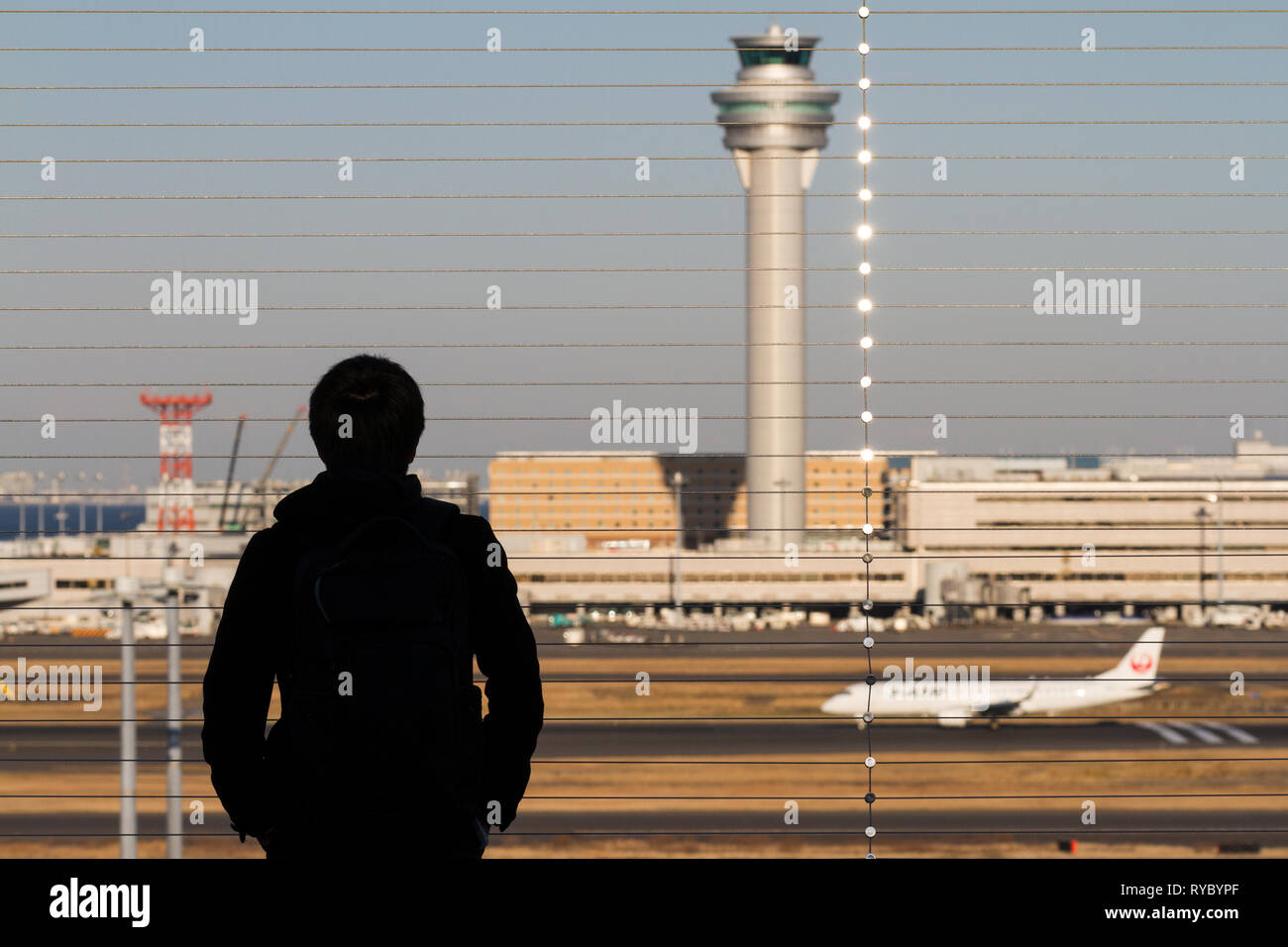 A man watches commercial airliners take off and land at the Observation Deck in Haneda International Airport, Tokyo, Japan. Stock Photo