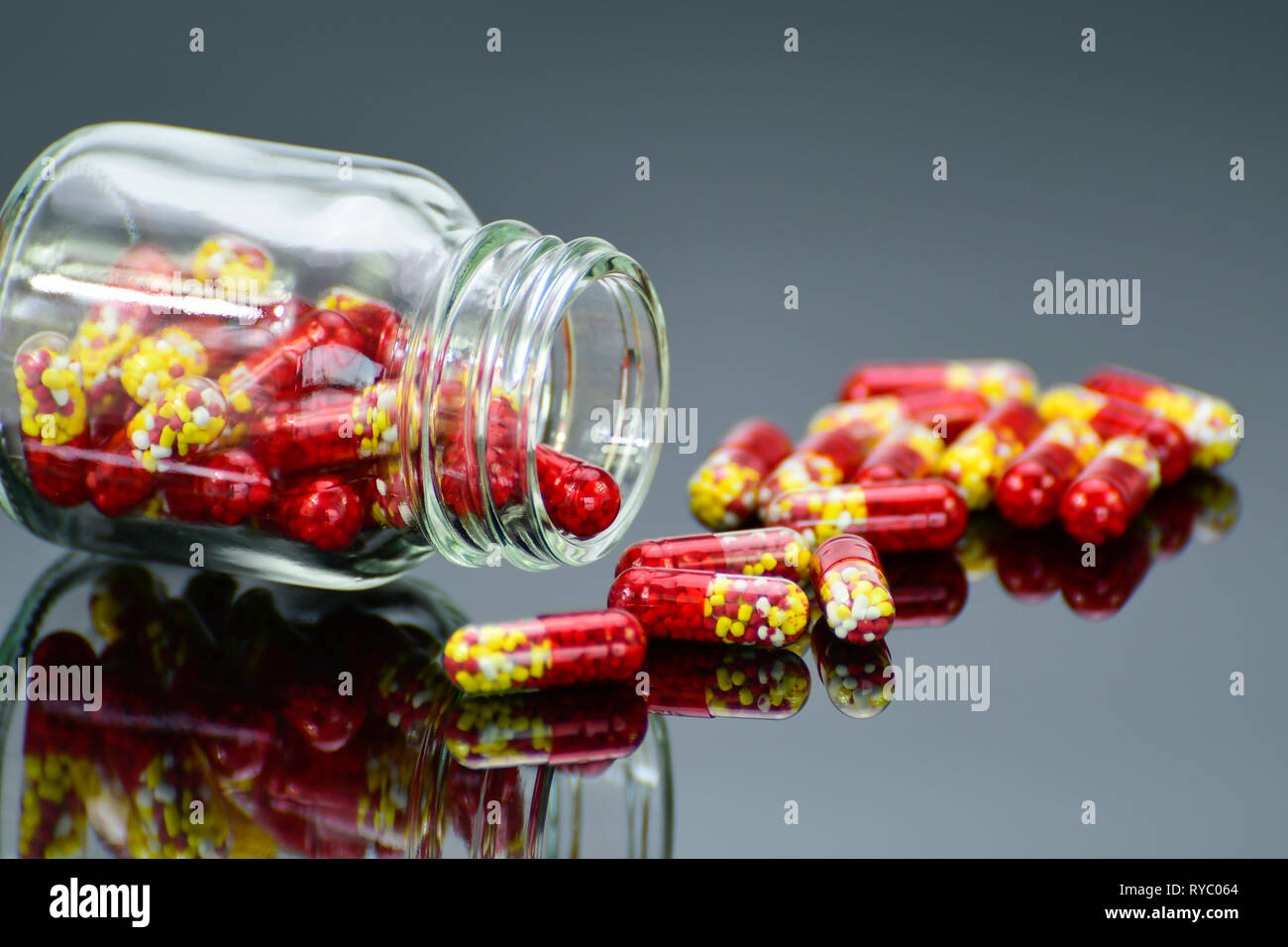 Pellets in transparent hard gelatin capsule on dark background. Stock Photo