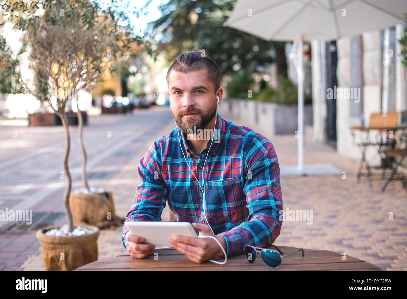 Handsome hipster guy working on digital tablet. Stock Photo