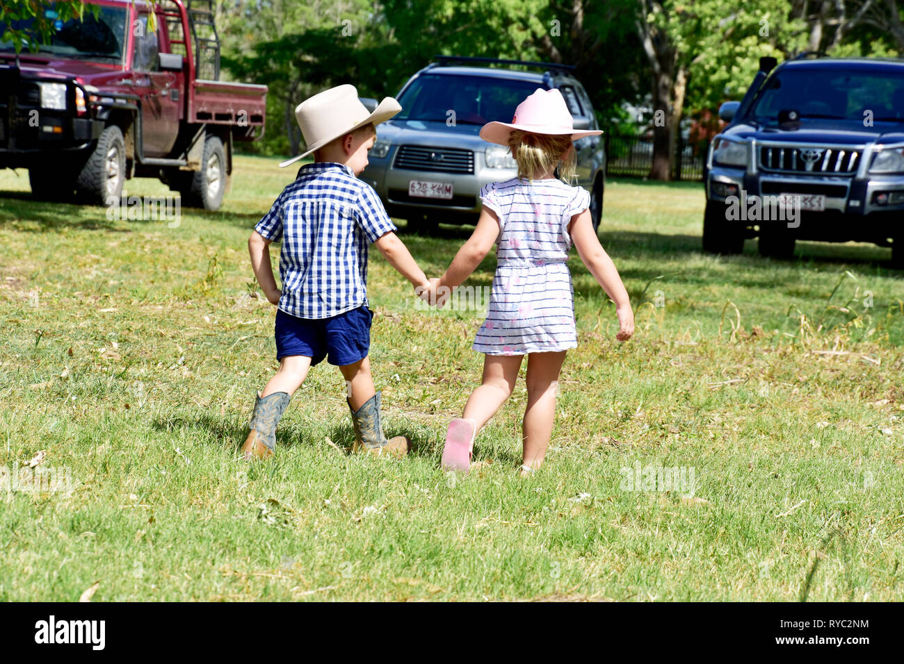 CHILDREN WALKING HAND IN HAND Stock Photo