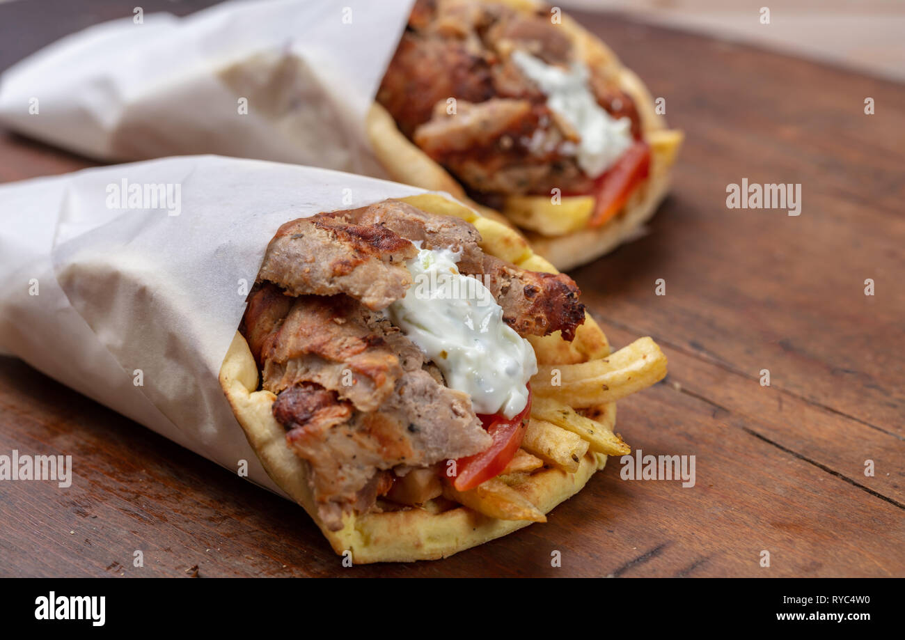 Gyro pita, shawarma, take away, street food. Two pita bread wraps with  meat, traditional greek turkish food on wooden table, closeup Stock Photo -  Alamy