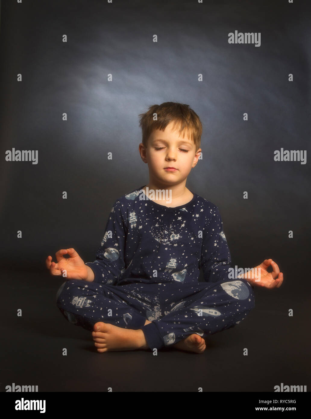 A 5 year old boy practicing yoga Stock Photo