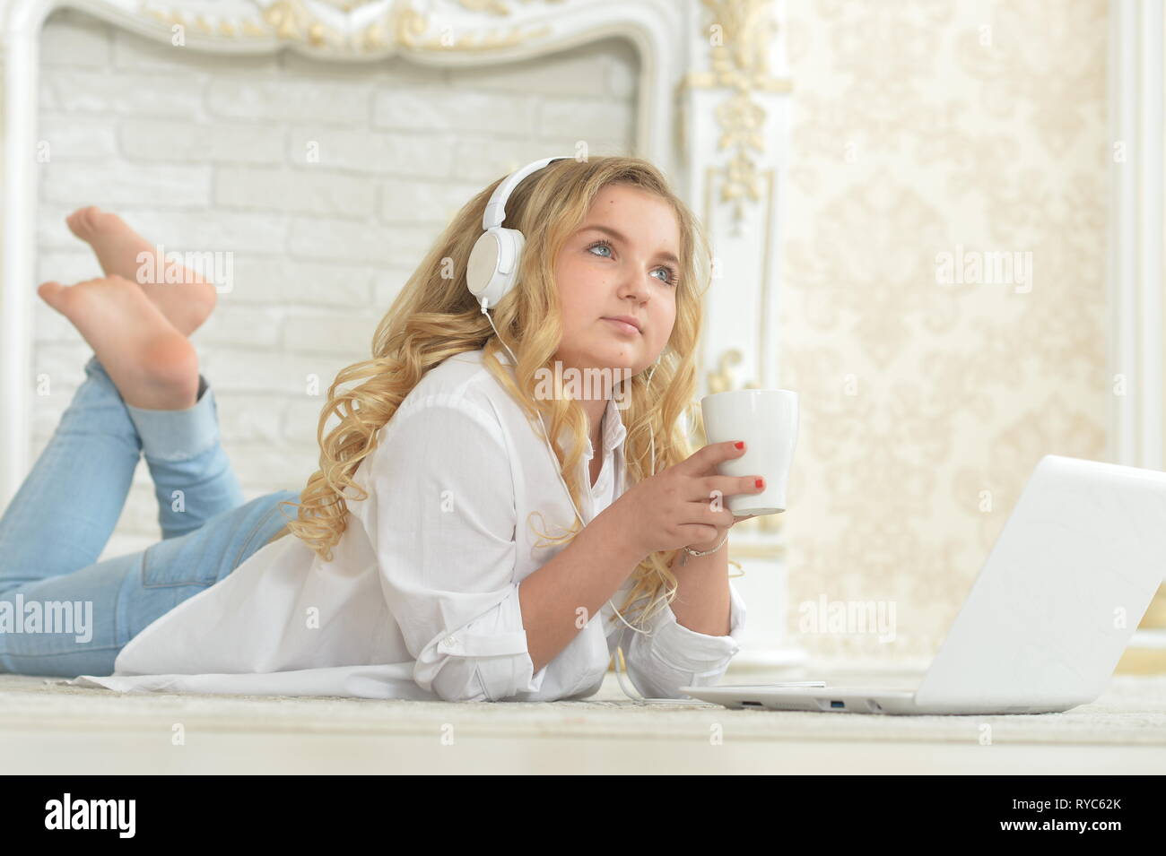 Portrait of teenage girl in headphones lying on floor Stock Photo - Alamy
