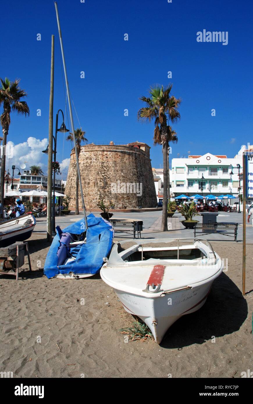 Small boats on the beach with the old watch tower and pavement cafes to the  rear in the Plaza de Torreon, La Cala de Mijas, Malaga Province, Andalusia  Stock Photo - Alamy