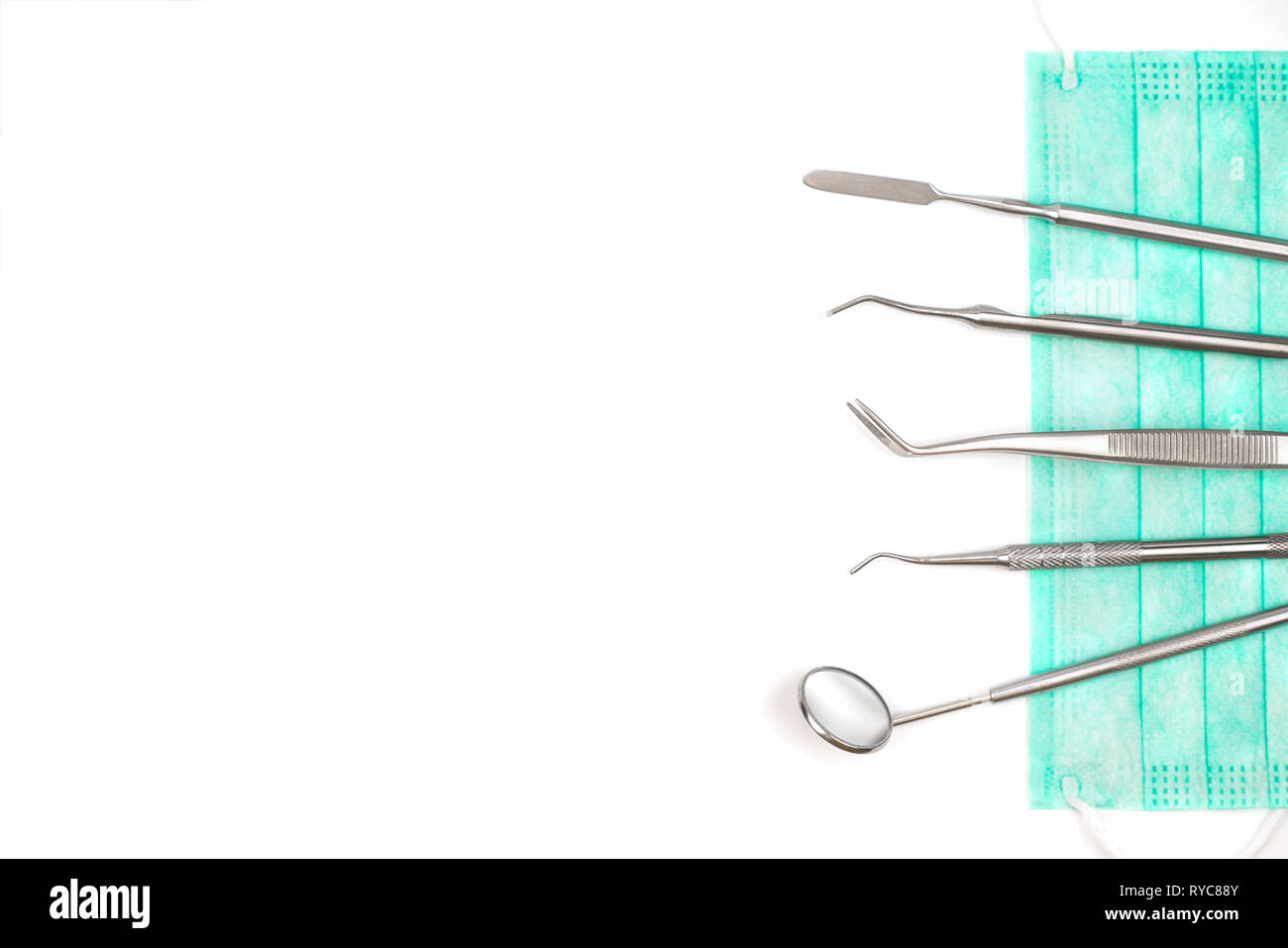 Dentist's tools and mask on white background. Stock Photo