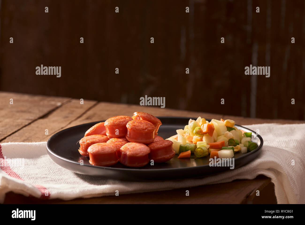 Sliced and fried sausage with salad seen from above close Stock Photo