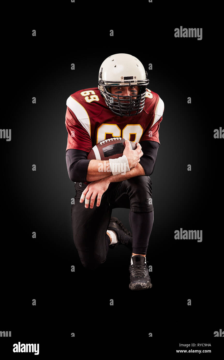 Portrait of American football player holding a ball with both his hands Stock Photo