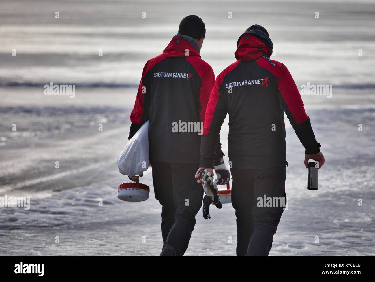 Two workers in branded Sigtunarannet clothing carrying metal curling stones at Sigtunarannet 2019, Lake Malaren, Sigtuna, Sweden, Scandinavia Stock Photo