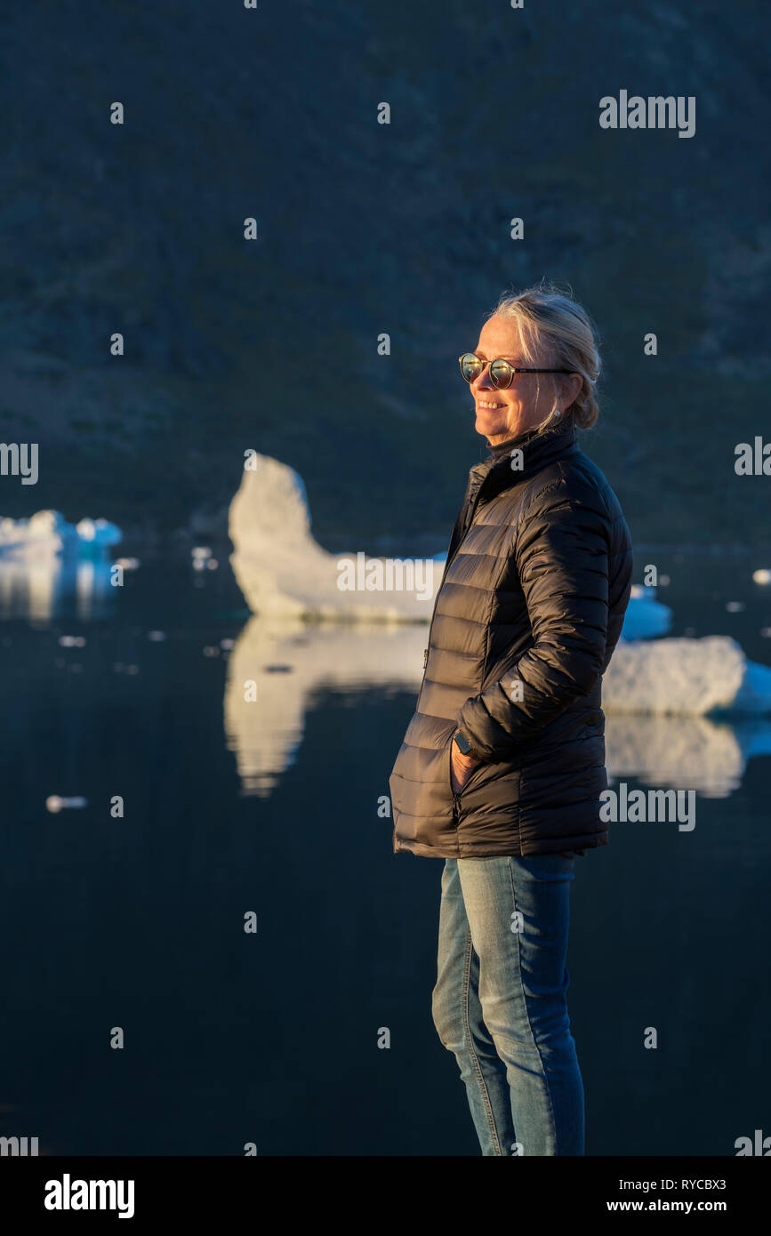 Female enjoying the evening sunshine, South Greenland Stock Photo