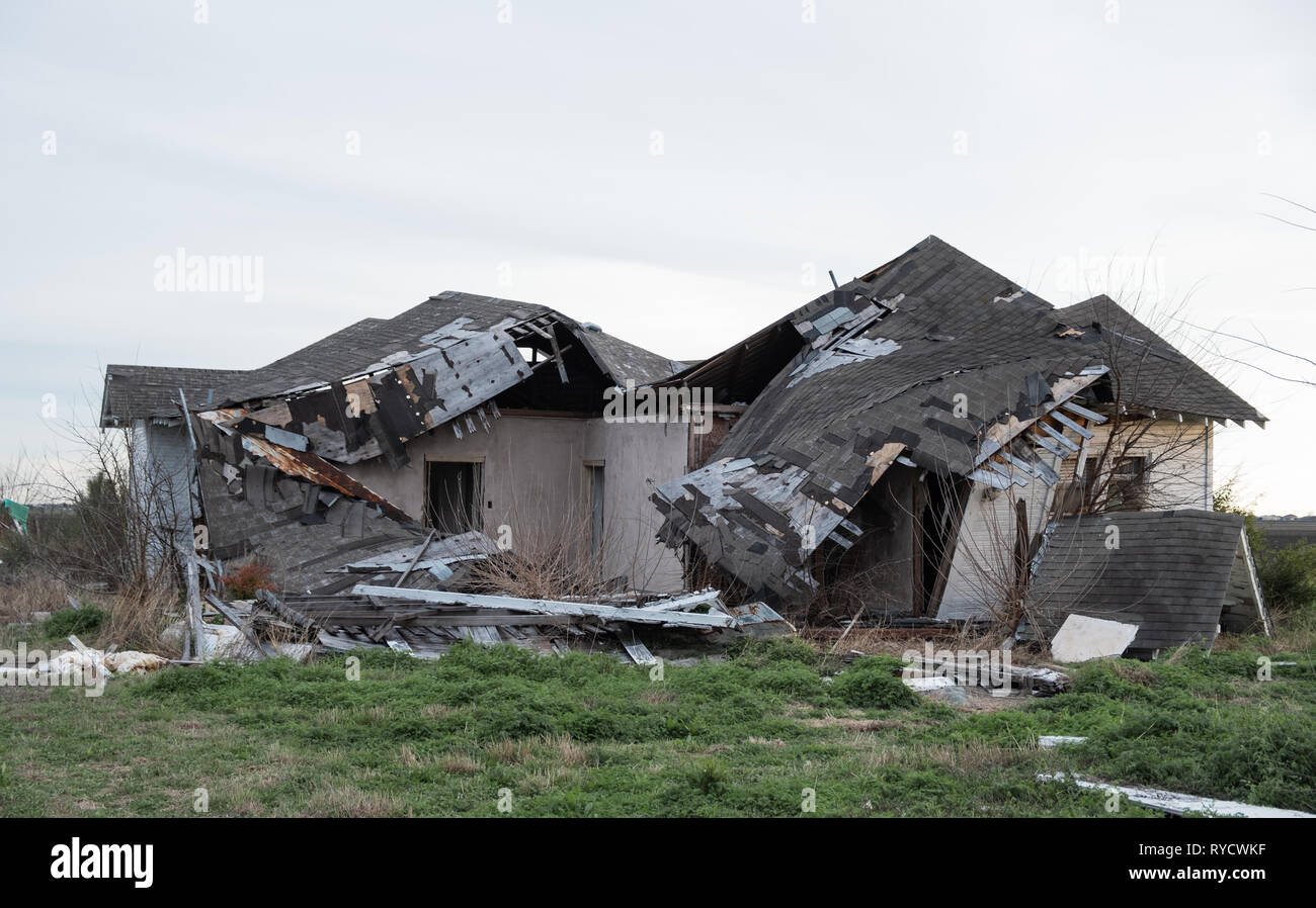 Abandoned house destroyed by storm, condition in near collapse/Collapsed roof of the total damaged domestic house indoor from natural disaster Stock Photo