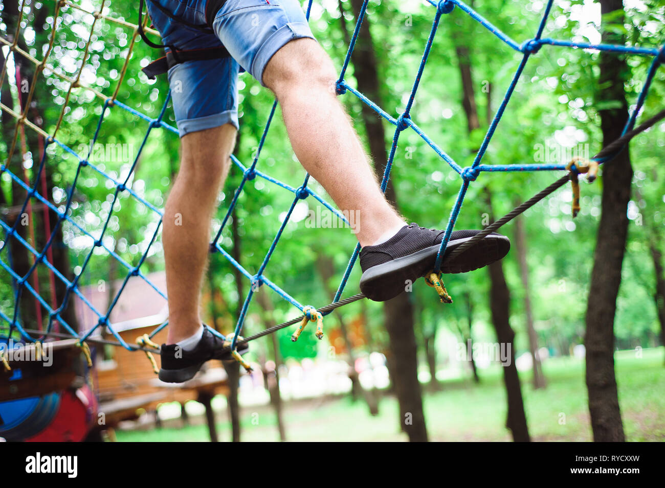 Hiking in the rope park beautiful sports guy Stock Photo Alamy