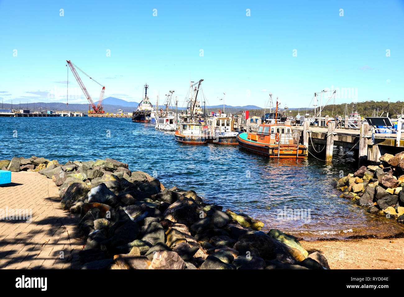 Fishing boats tied up at Eden Harbour wharf on Two Fold Bay on the New South Wales south coast Stock Photo