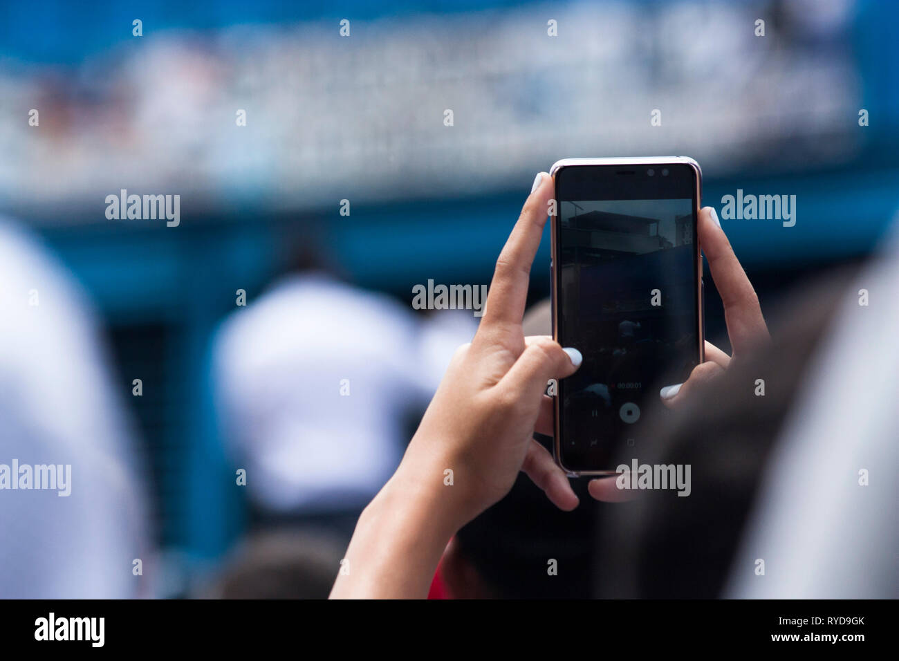 A woman holds a Smartphone during a protest in Caracas. Stock Photo