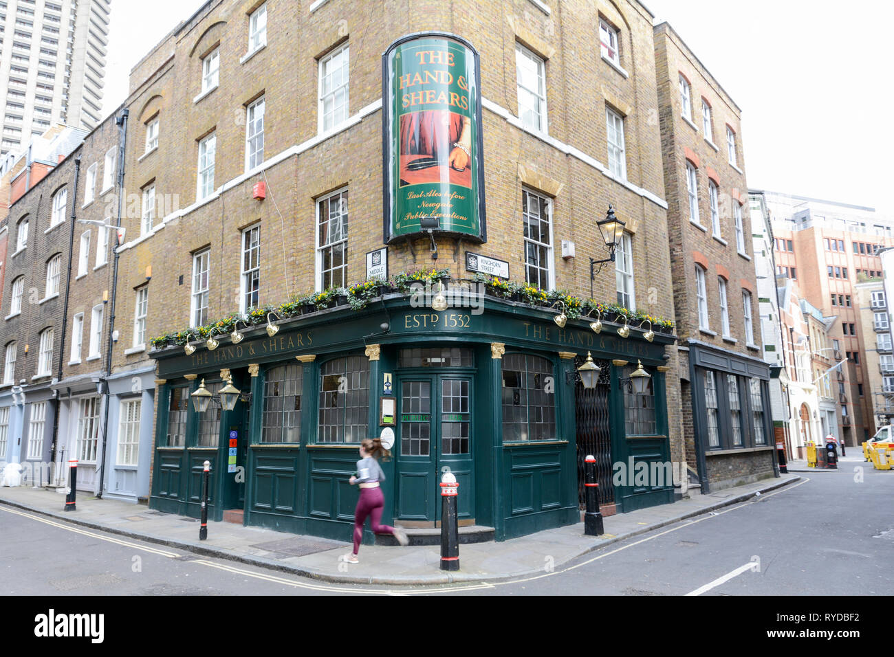 A jogger in front of The Hand and Shears public house on Middle Street, Smithfield, London, EC1, UK Stock Photo