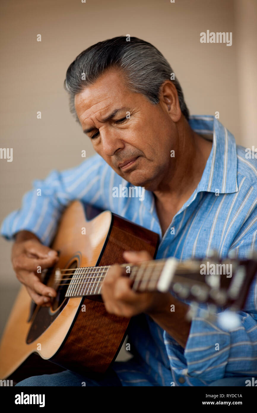 Portrait of man playing acoustic guitar. Stock Photo