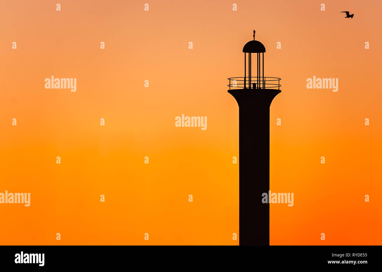 The sun sets on the Broadwater Beach Marina channel lighthouse, Feb. 24, 2019, in Biloxi, Mississippi. Stock Photo