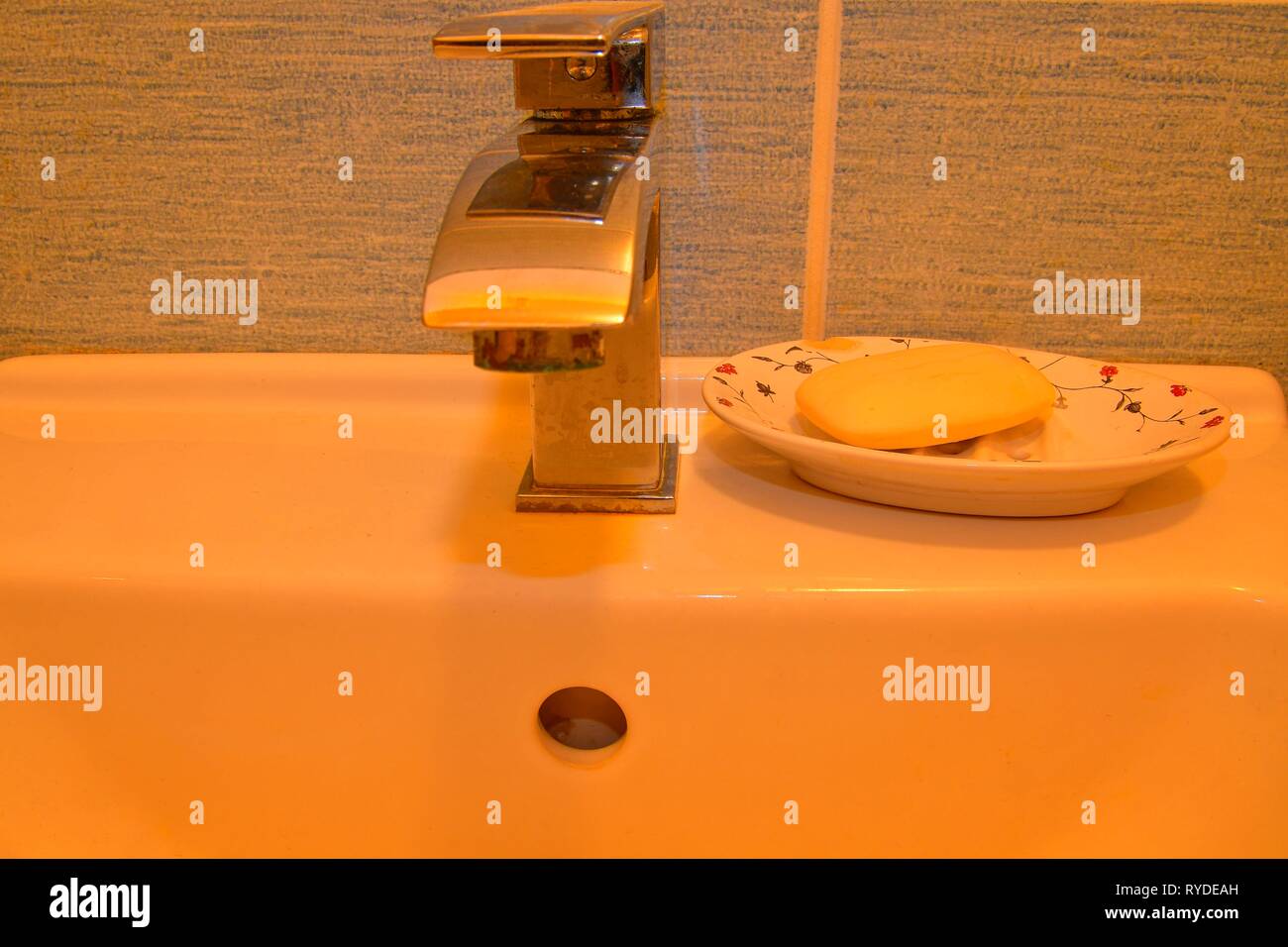 Modern faucet and classic soap dish on white basin. Minimalist concept. Stock Photo