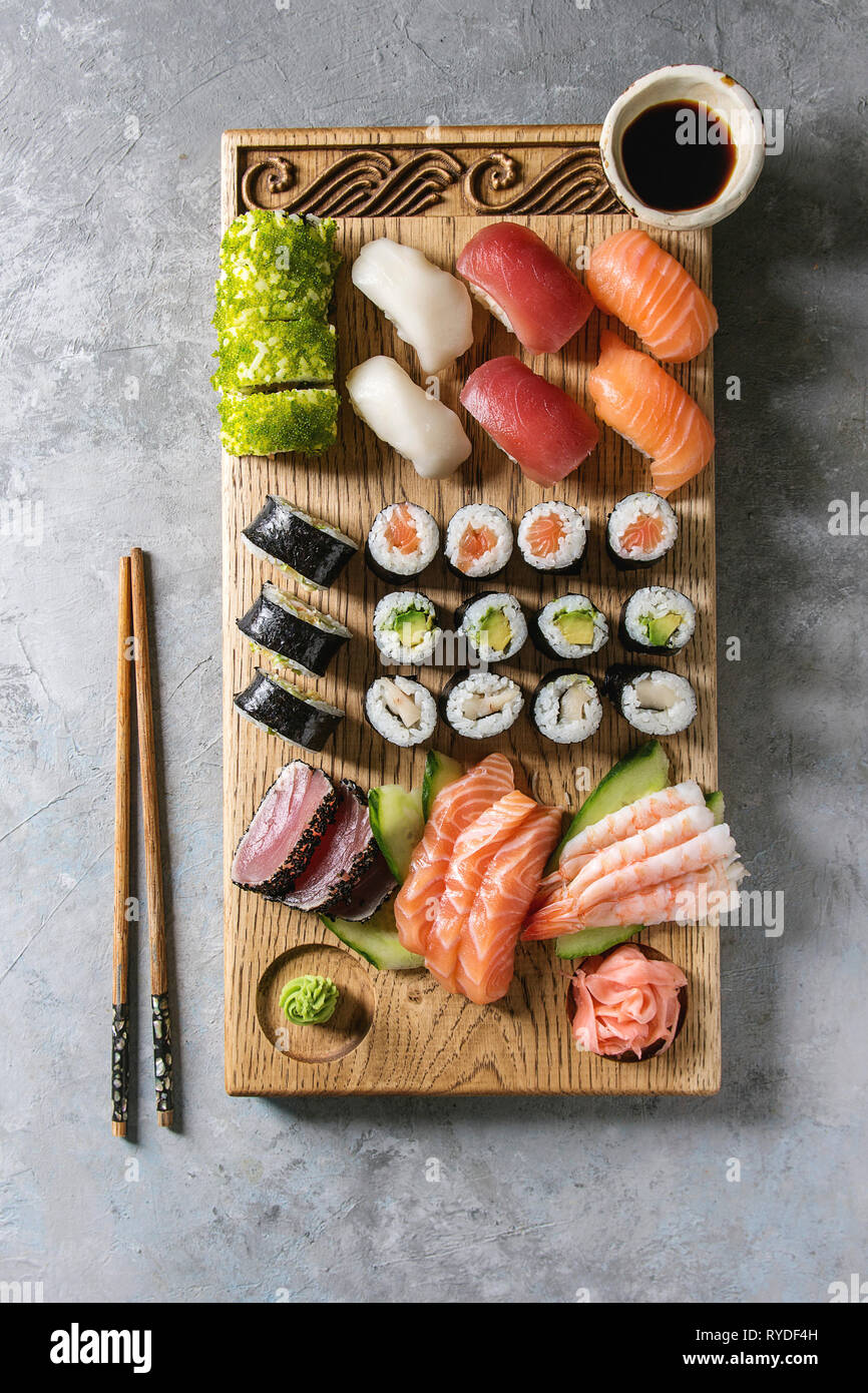 Sushi Set nigiri sashimi and sushi rolls on wooden serving board