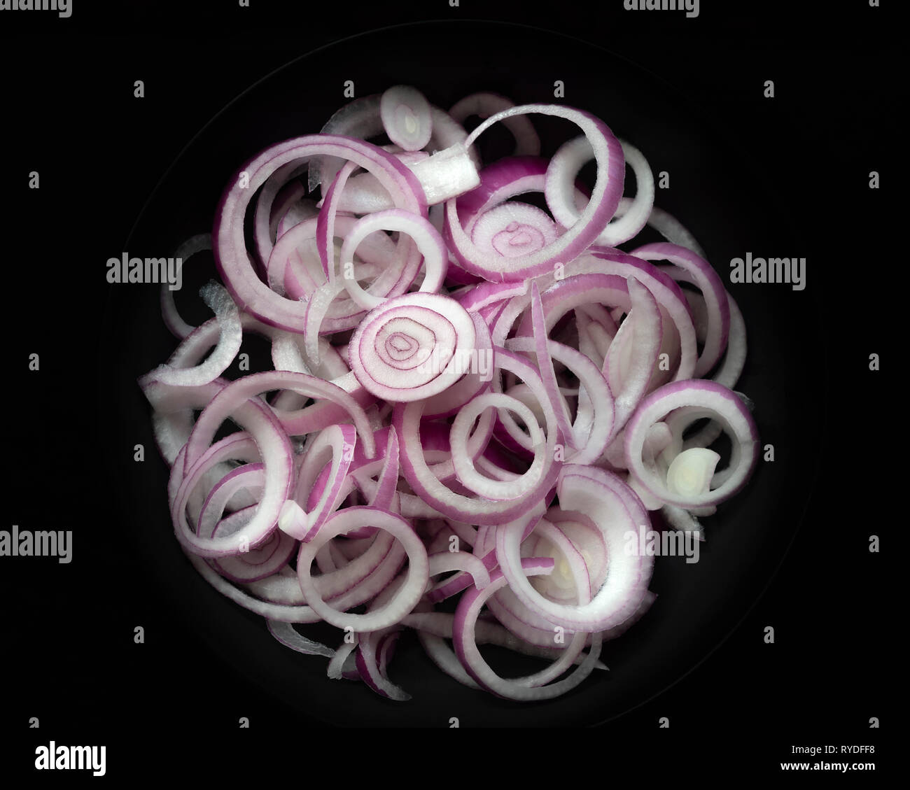 Sliced red onions on a black background. Stock Photo