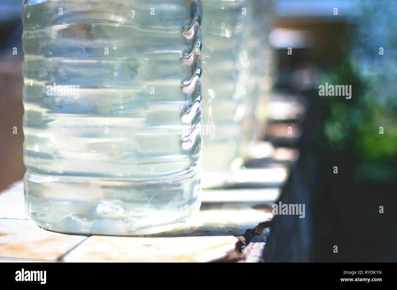 Row of Plastic Bottles Filled with Clean Water From a Public Well on a