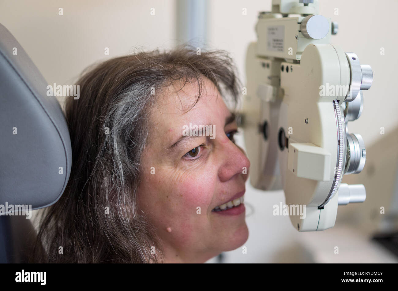 Beim Augenoptiker / Augenarzt / Brille / Augenwerte überprüfen / Frau Sehtest beim Augenoptiker. Stock Photo