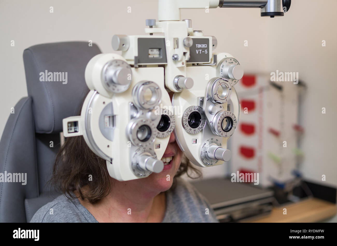 Beim Augenoptiker / Augenarzt / Brille / Augenwerte überprüfen / Frau Sehtest beim Augenoptiker. Stock Photo