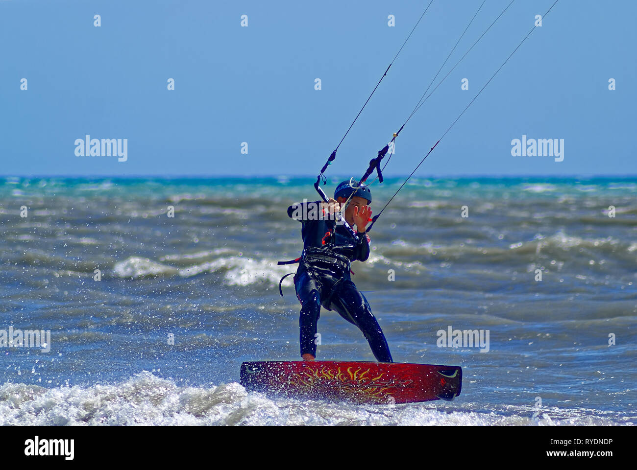 Kite boarder starting to fly over the sea during a windy day in french riviera Stock Photo