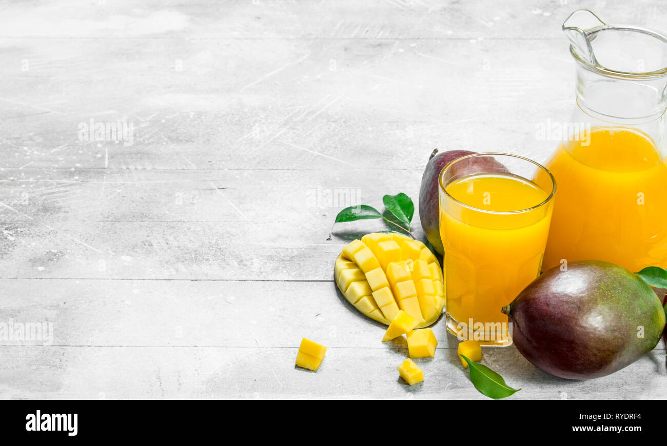 Mango juice in pitcher. On white rustic background Stock Photo - Alamy