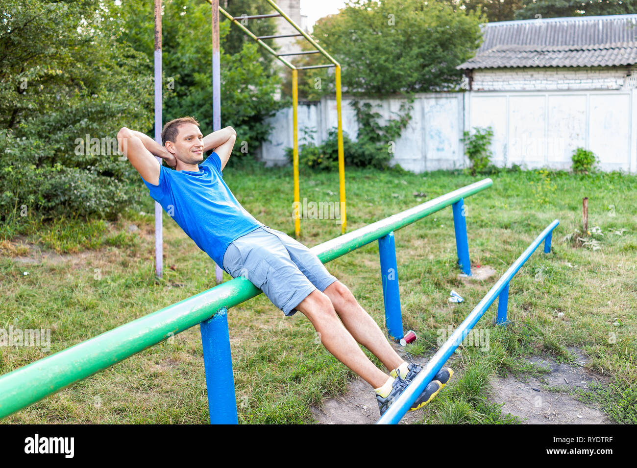 Fit man doing calisthenics workout crunches sit ups on parallel