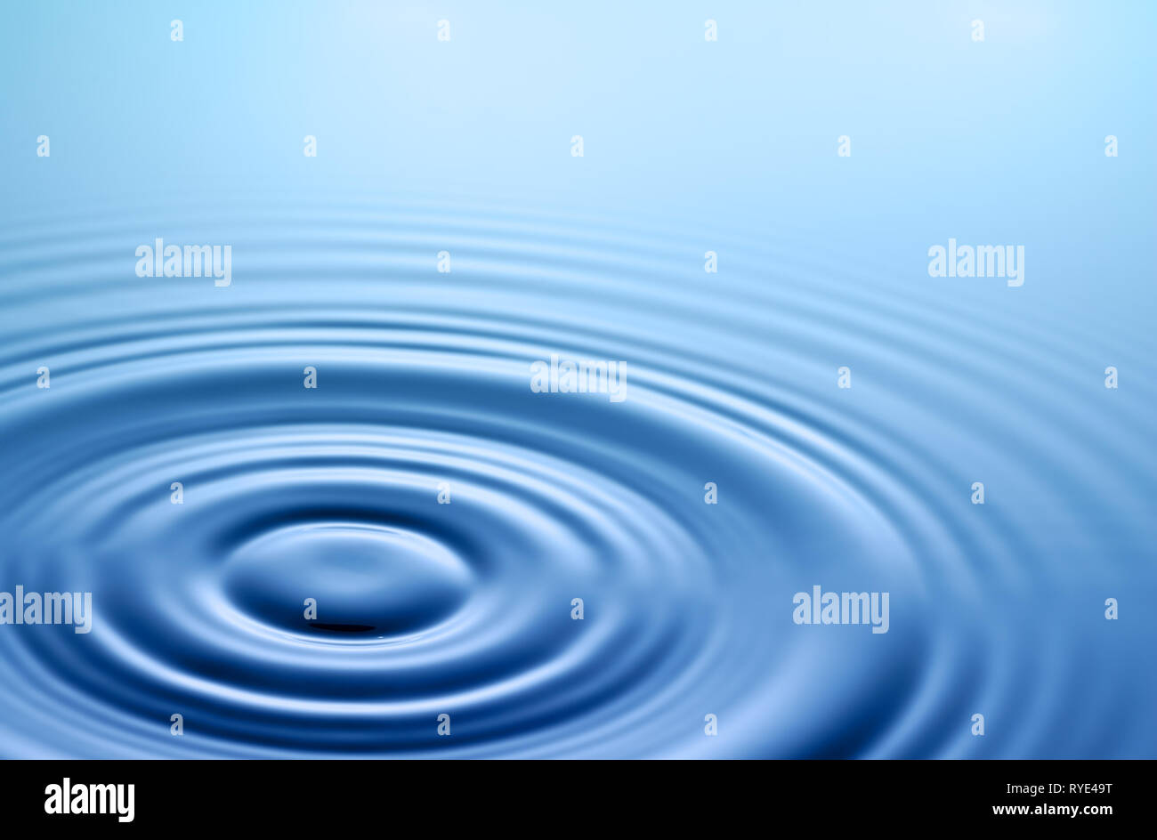 Tranquil scene. Symmetrical smooth circles and waves on water surface after splash. Stock Photo