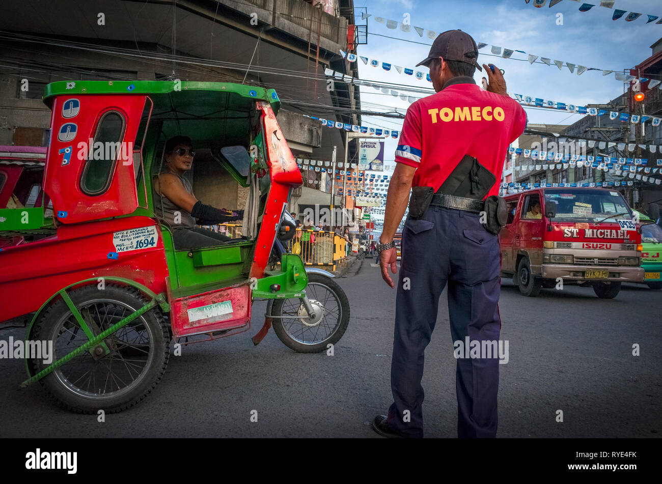 Filipino man stands on stret directing traffic in Tacloban City, Leyte - Philippines Stock Photo