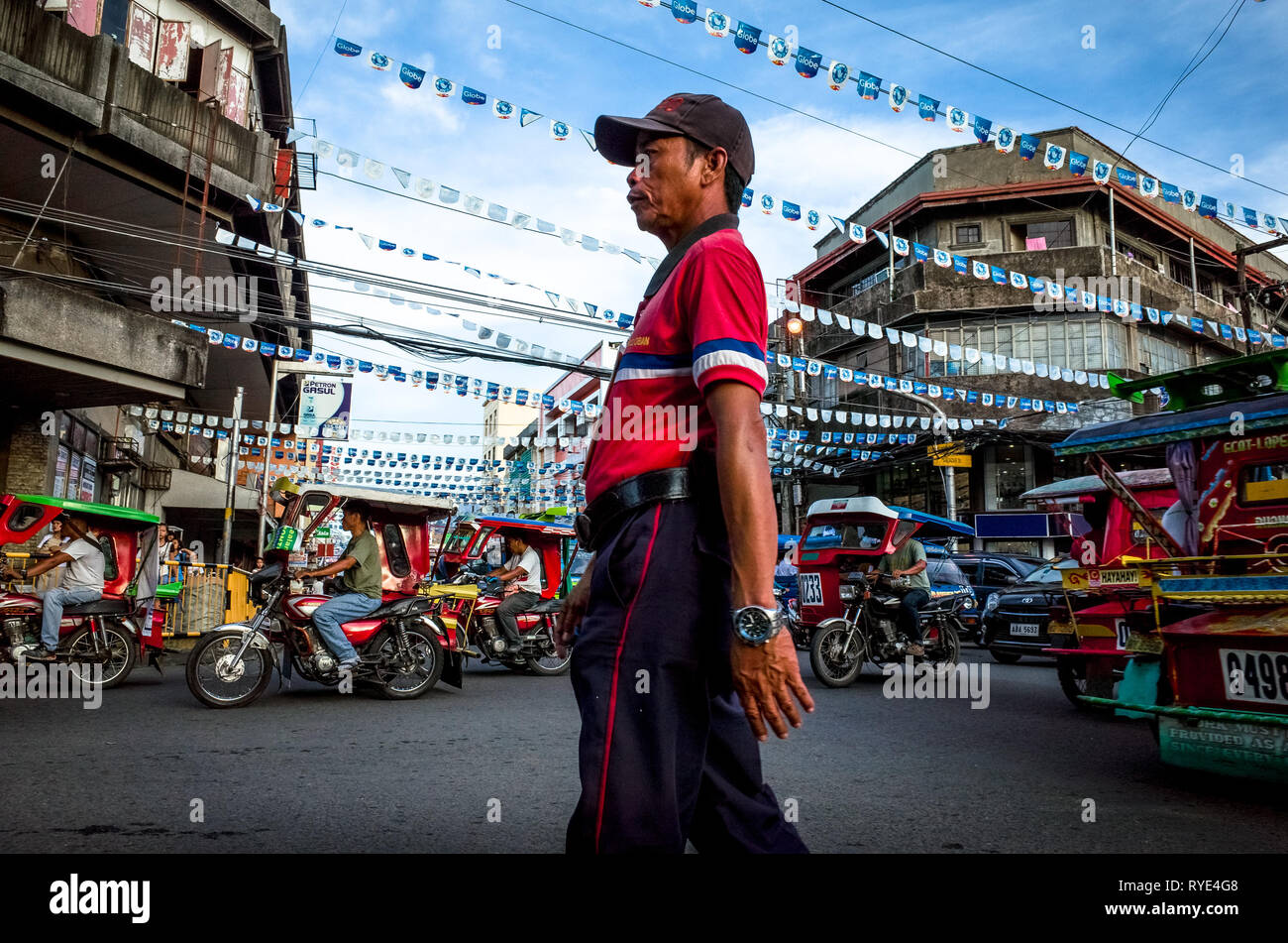Traffic enforcer and tricycles in downtown Tacloban City, Leyte - Philippines Stock Photo