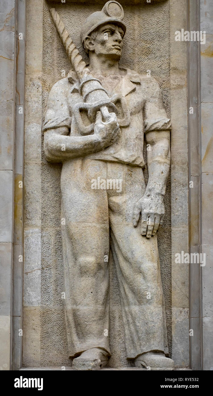 Bas relief of a symbolic coal miner with headlamp in the Socialist Realist artistic style near the Constitution Square of Warsaw, Poland. Stock Photo